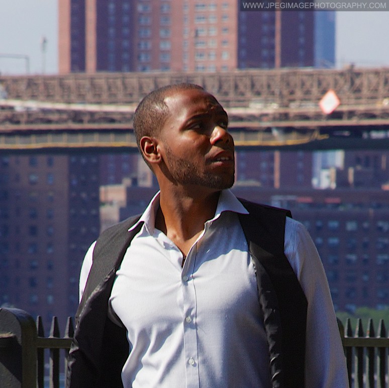 Afro-American male walking down the Brooklyn Heights Promenade, located in Brooklyn Heights, New York while looking to his left.
