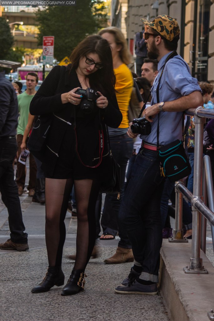 Two people taking photographs and reviewing photos, during the DUMBO Arts Festival located in DUMBO Brooklyn, Sunday September 29, 2013.