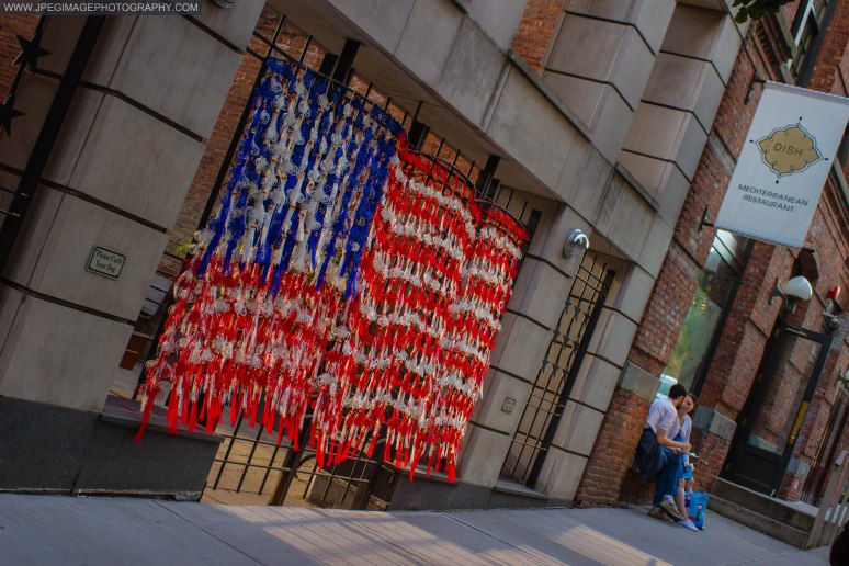 Tassels hanging on a gate made to look as the flag of the United States, as an artist work is shown during the DUMBO Arts Festival located on Washington Street in DUMBO Brooklyn, Sunday September 29, 2013.