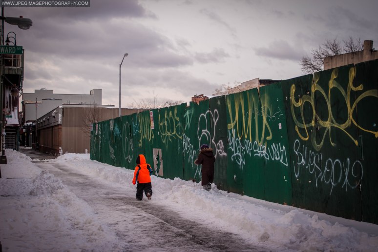 Woman and child walking in the snow along Broadway in Bedford Stuyvesant, Brooklyn New York.